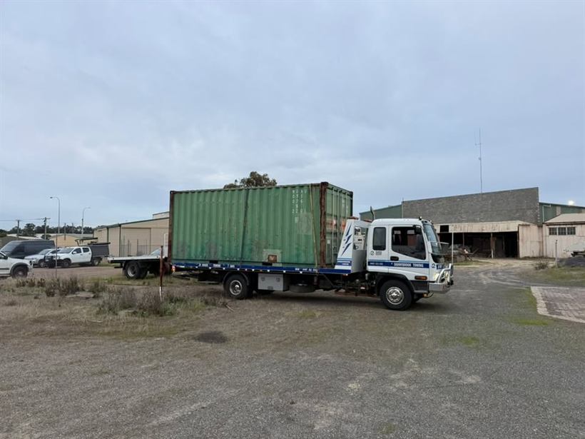 Green sea container loaded on the tilt tray
