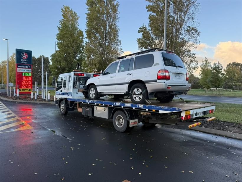 White LandCruiser on the tilt tray at a service station