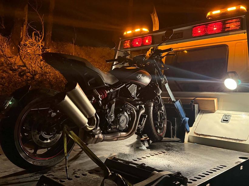 Motorbike strapped on the tilt tray at night